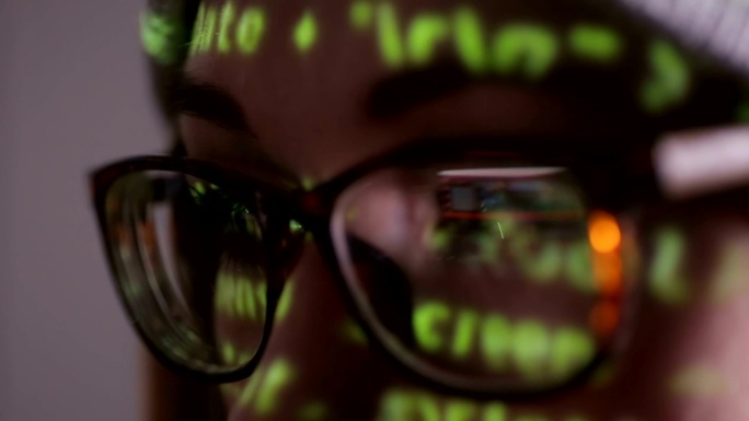 戴眼镜的女性晚上在黑暗中操作电脑
