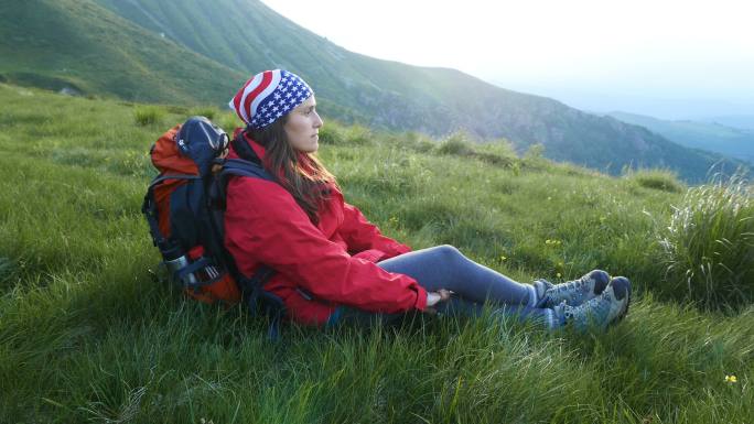 女孩在山上的草地上休息