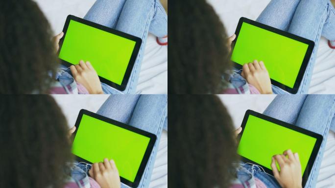 使用绿色屏幕的电子平板的女人