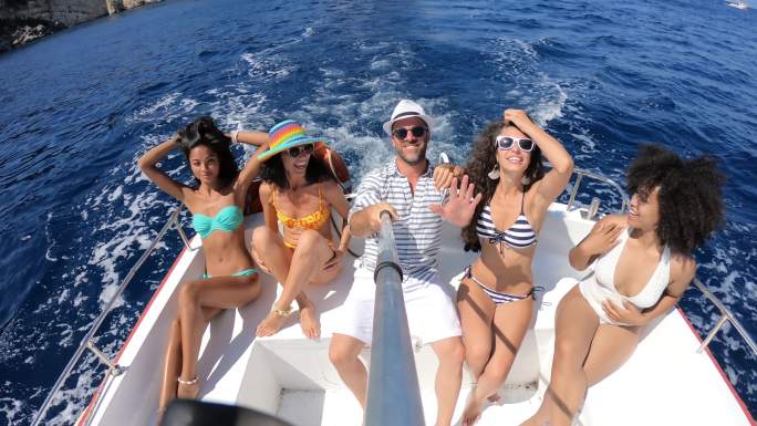 朋友们在船上自拍和享受暑假