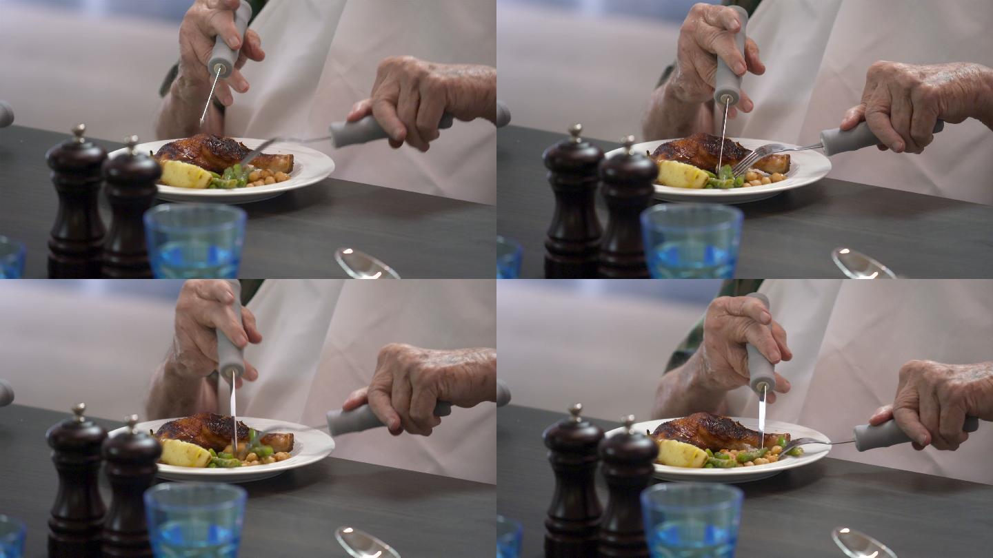 一位患有关节炎的老人用刀叉吃饭