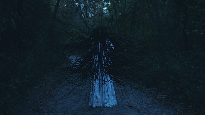 长着黑色触须的怪物站在树林里