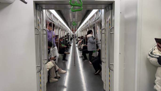 整洁狭长的地铁车厢乘客乘车在看手机