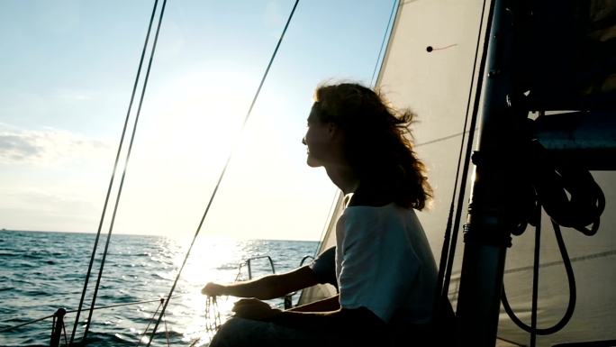 年轻女子坐在桅杆附近的甲板上