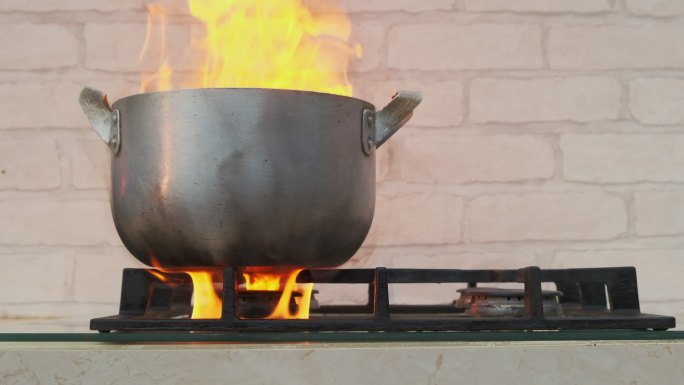 煤气炉上的烹饪锅。家庭火灾原因概念。