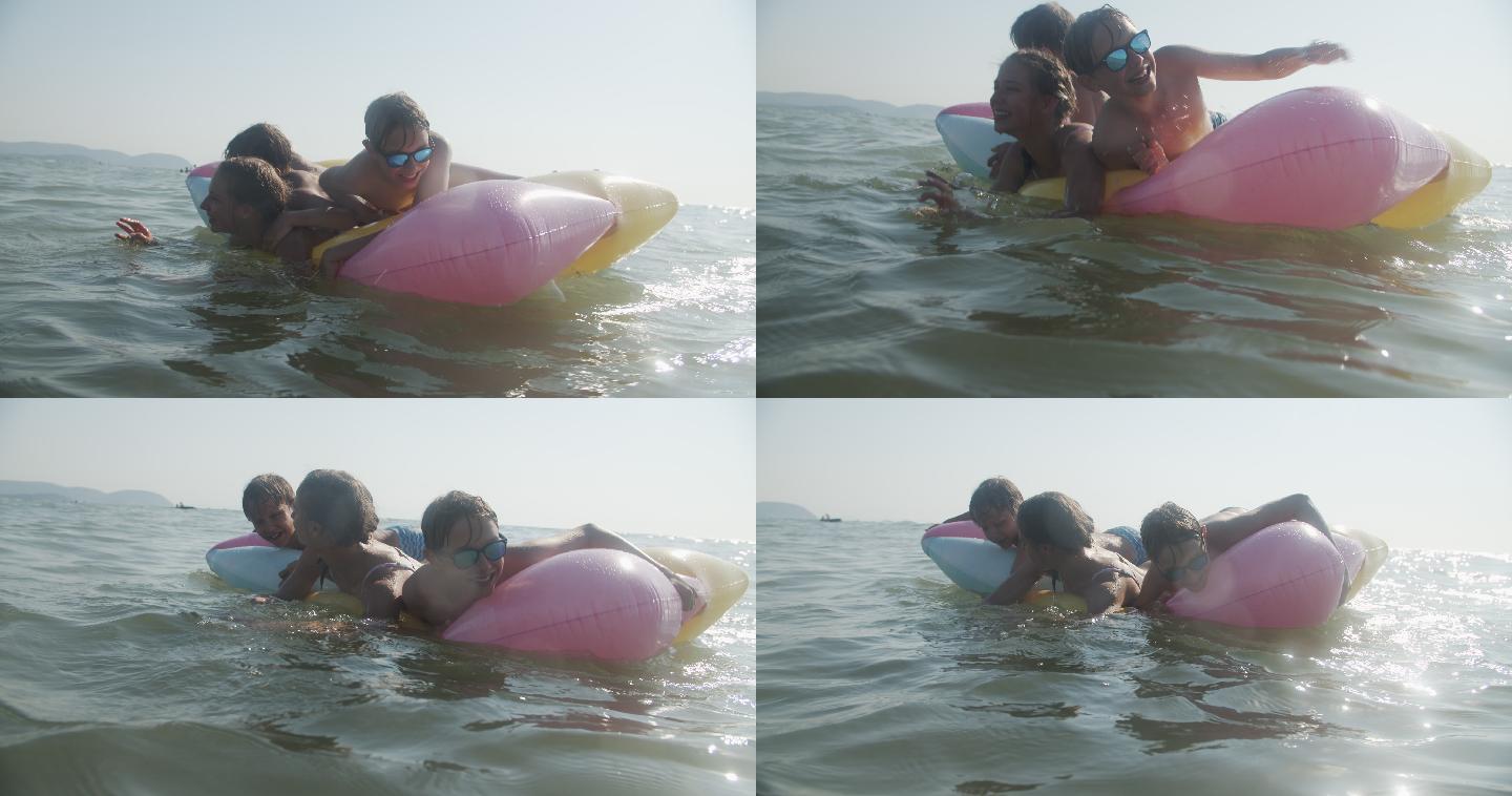 兄弟姐妹在海边的气垫上玩耍