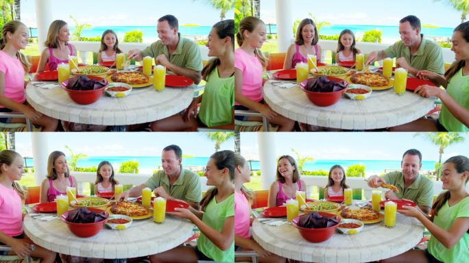 年轻的白人家庭在海滩边户外用餐