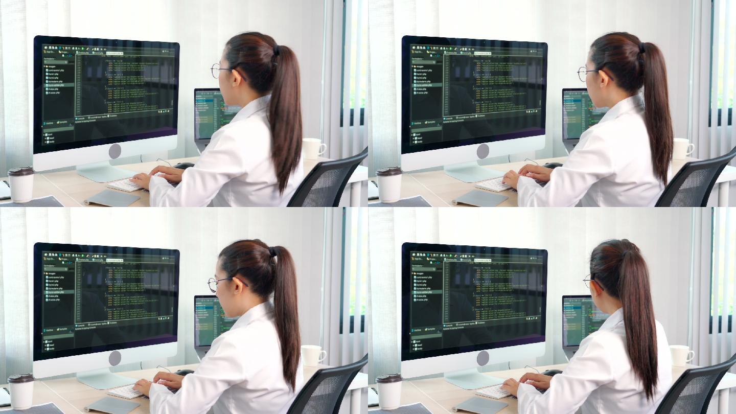 女程序员在办公室电脑上输入源代码编程