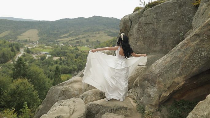 美丽的新娘站在山丘上。