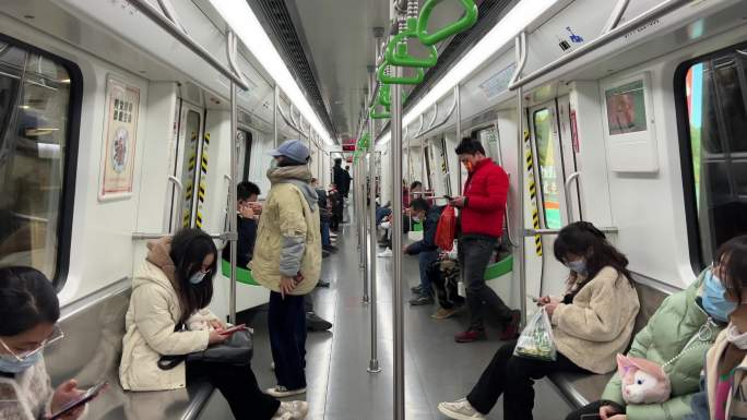 南宁地铁列车减速进站列车车厢里的乘客人群