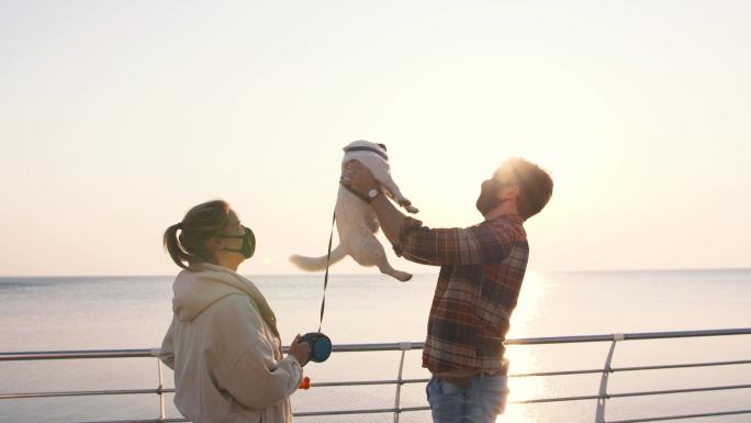 幸福夫妇在海边和狗狗玩耍