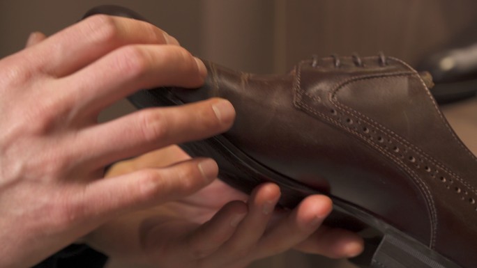 男性客户在购买棕色皮鞋的特写镜头。