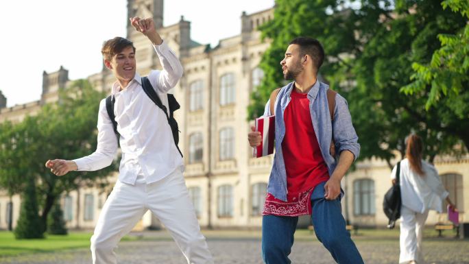 兴奋的男大学生在校园里跳舞