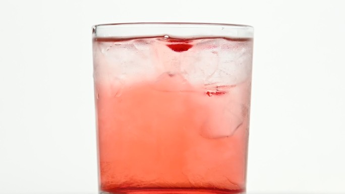 冰块在粉色鸡尾酒杯中旋转