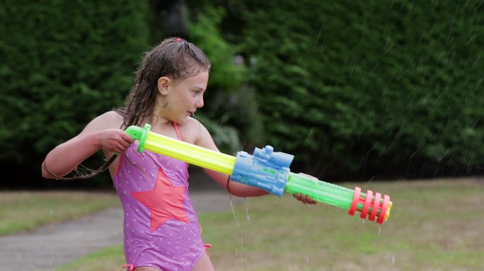 儿童在花园玩水枪儿童玩水童年