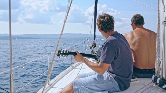 年轻人在帆船上弹吉他