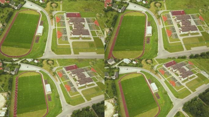 红色跑道和绿色草地足球场的体育场。