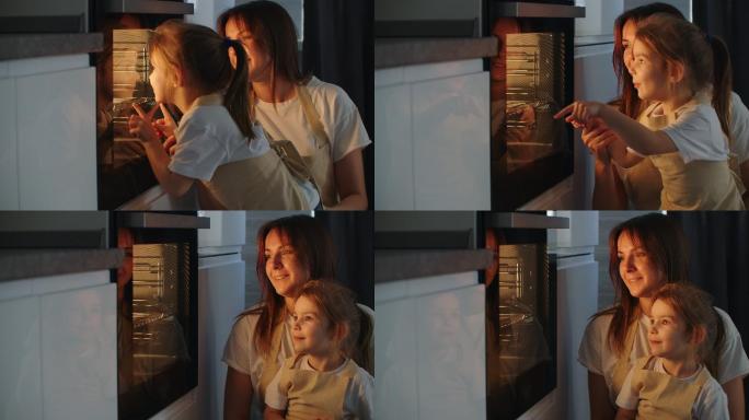 母亲和女儿看着烤箱里做馅饼