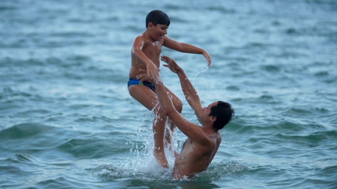 男孩和父亲在海中嬉戏