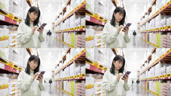 年轻女性在现代超市里使用智能手机购物