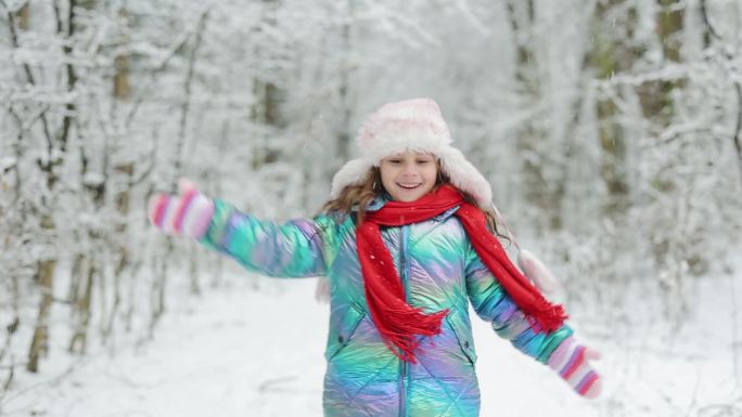 小女孩在下雪的冬日里尽情奔跑