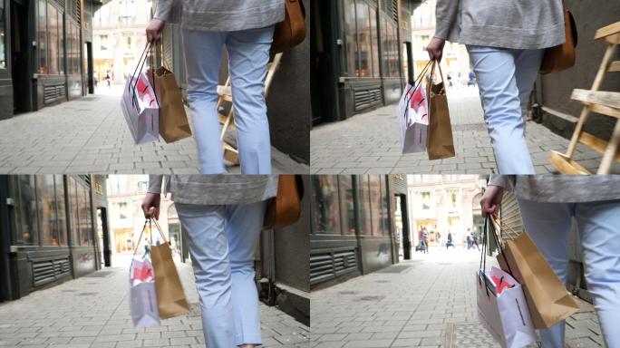 拿着购物袋的女子逛街消费小巷