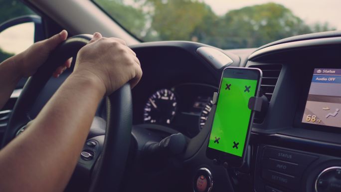 在车上使用绿幕智能手机的人