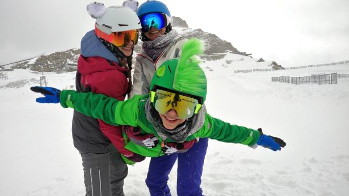 母亲和孩子们在阿尔卑斯山滑雪玩得很开心