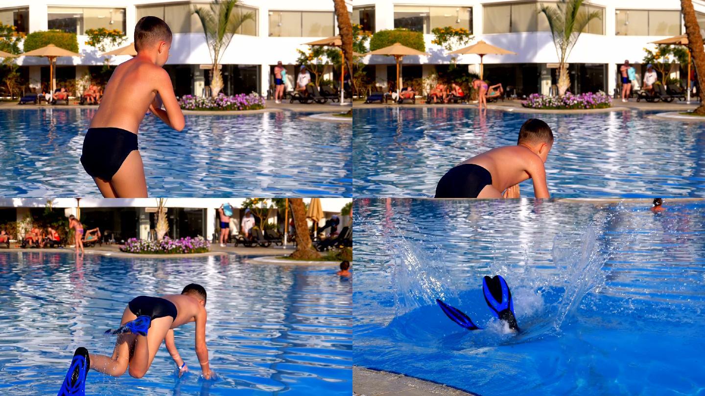 穿着脚蹼的快乐男孩跳进蓝色的水池。