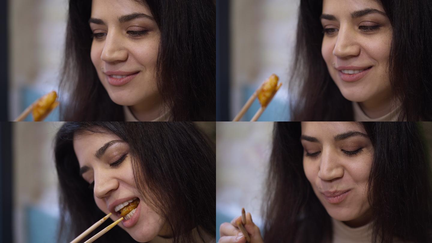 年轻女子的笑脸，用筷子品尝美味健康的烤虾
