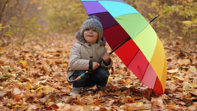 打着彩虹雨伞的小孩子