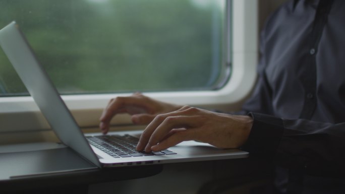 在火车上旅行时使用笔记本电脑的人