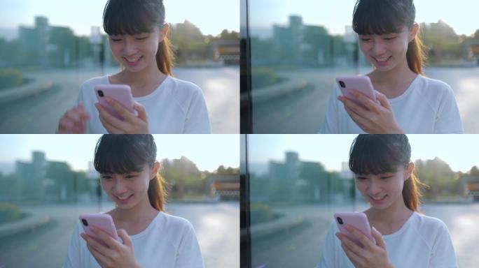 亚洲女性在城市街道上使用智能手机