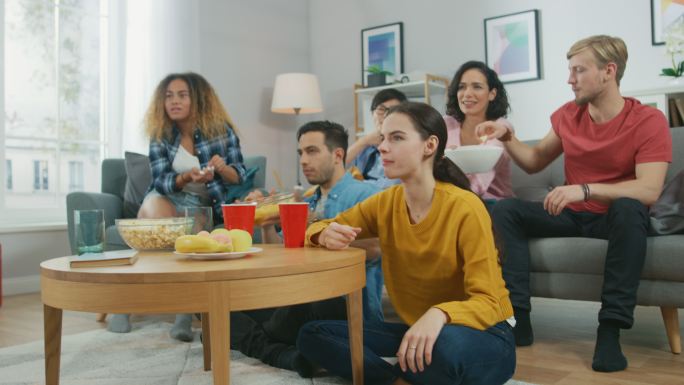 在家里，朋友们一起看电视，吃零食，喝饮料