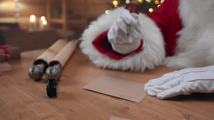 圣诞老人拿着墨水笔在信封上签名