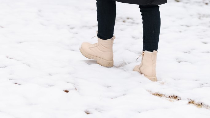 4K年轻女性在雪地里行走脚步特写