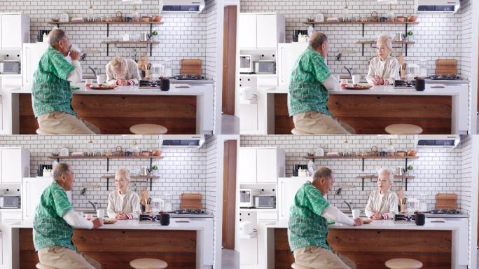 一对老年夫妇一起在厨房里吃早餐