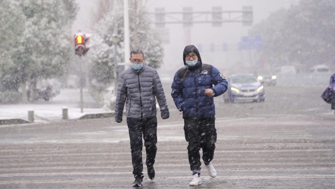 下雪路口上的行人