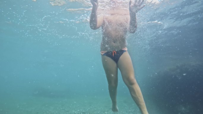 男孩带着海石在透明的海水中潜水