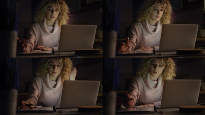 一名女子深夜在使用笔记本电脑