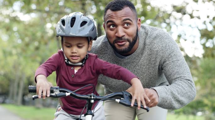 男子教儿子骑自行车