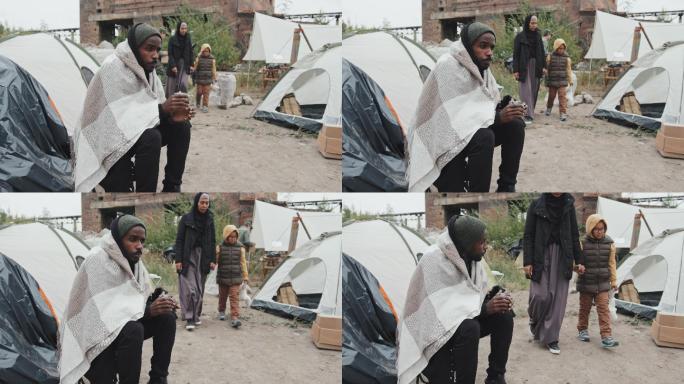 无家可归的人坐在帐篷外