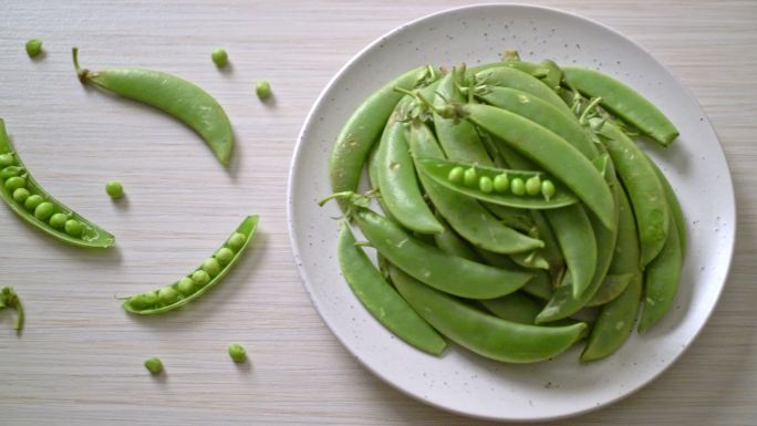白盘子上的新鲜甜绿豌豆