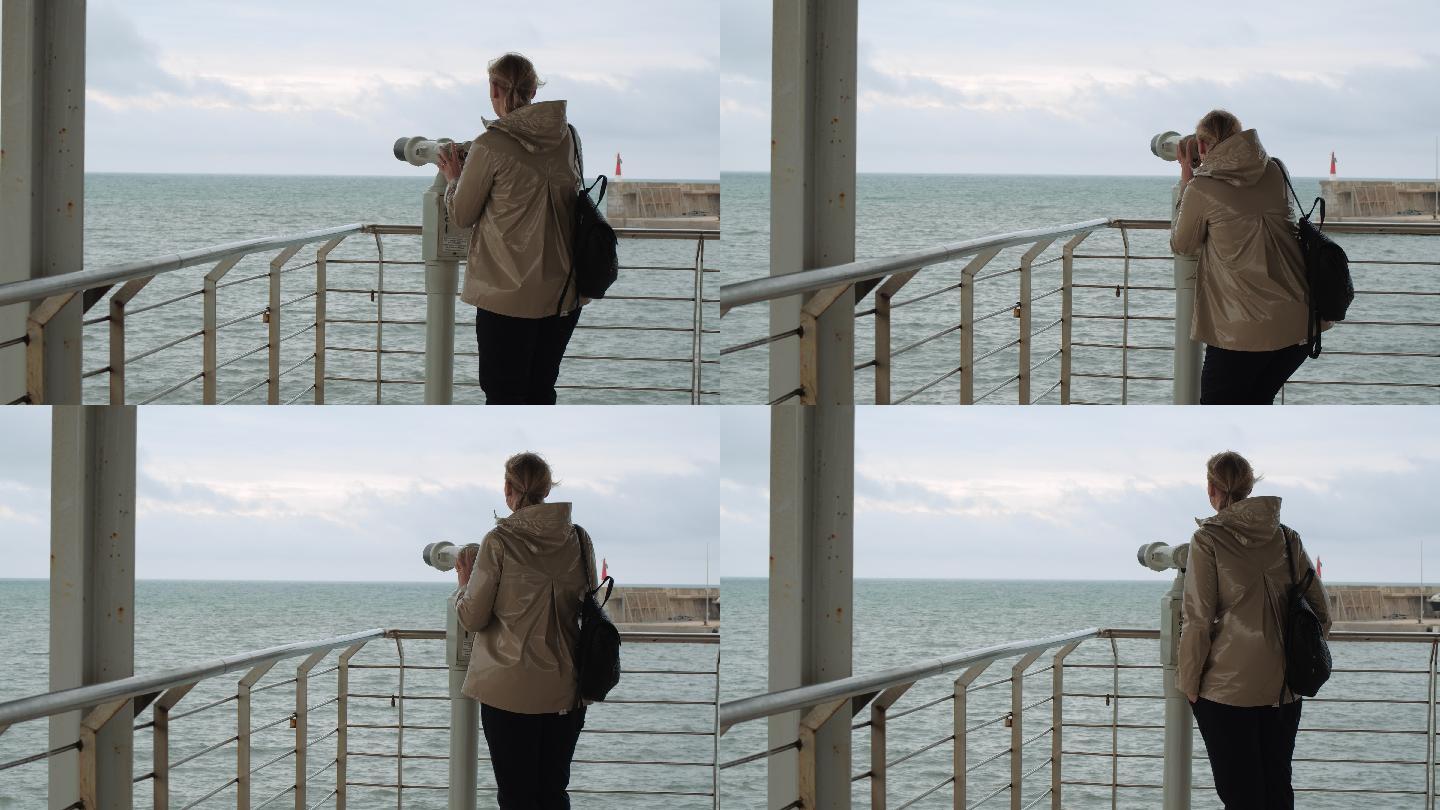 女人用双筒望远镜看海