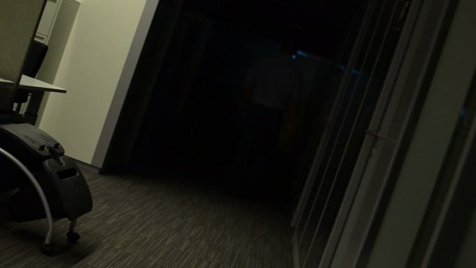 走在走廊里的男人夜晚开灯