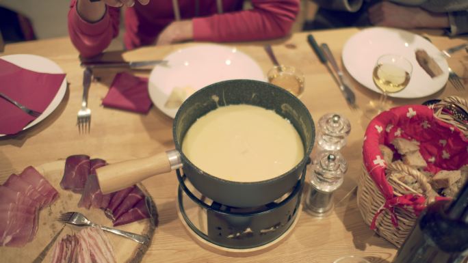 一家人在餐桌旁享用瑞士火锅奶酪