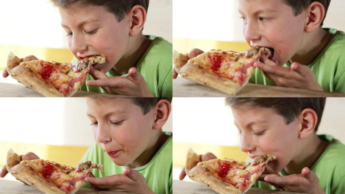 男孩正在吃一片披萨