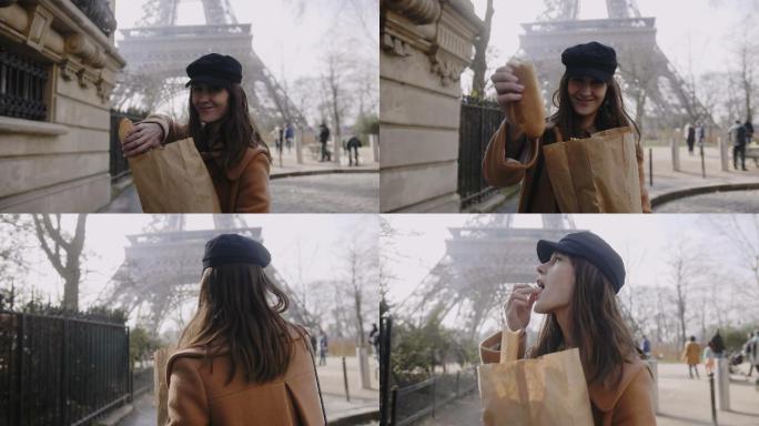 女人走在埃菲尔铁塔附近吃面包。
