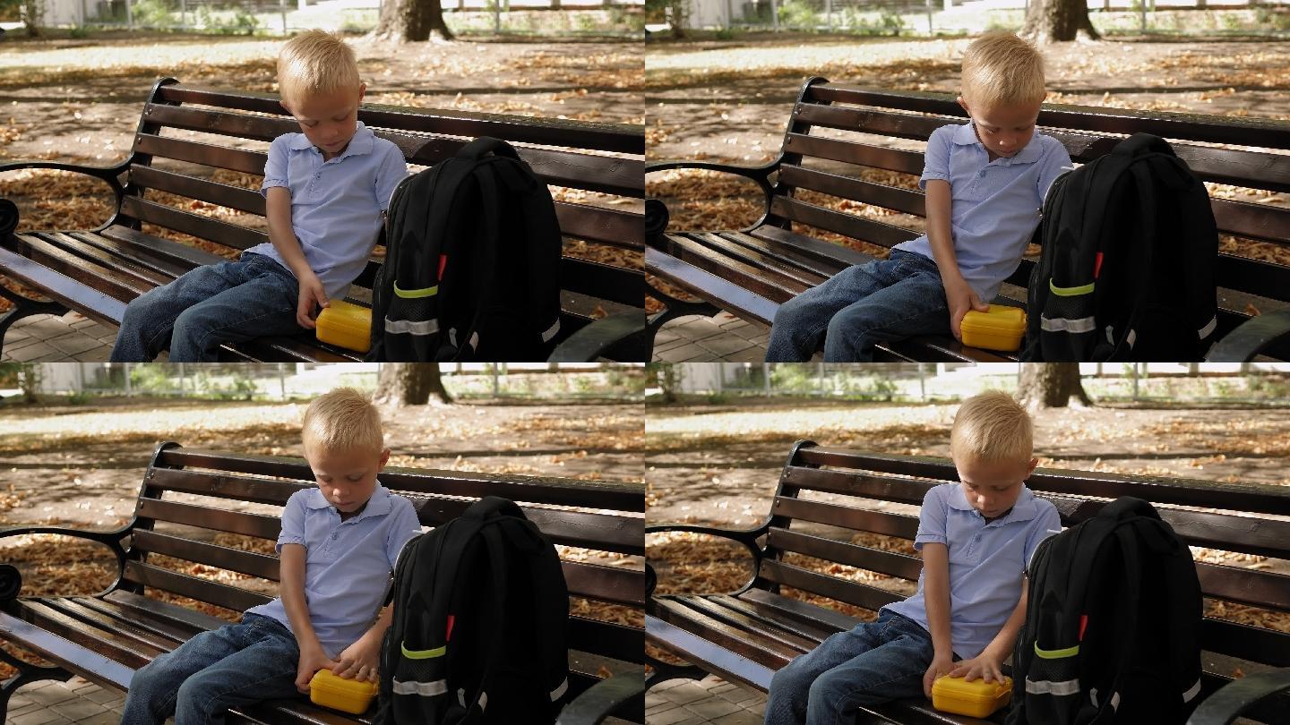 小男孩坐在公园的长椅上