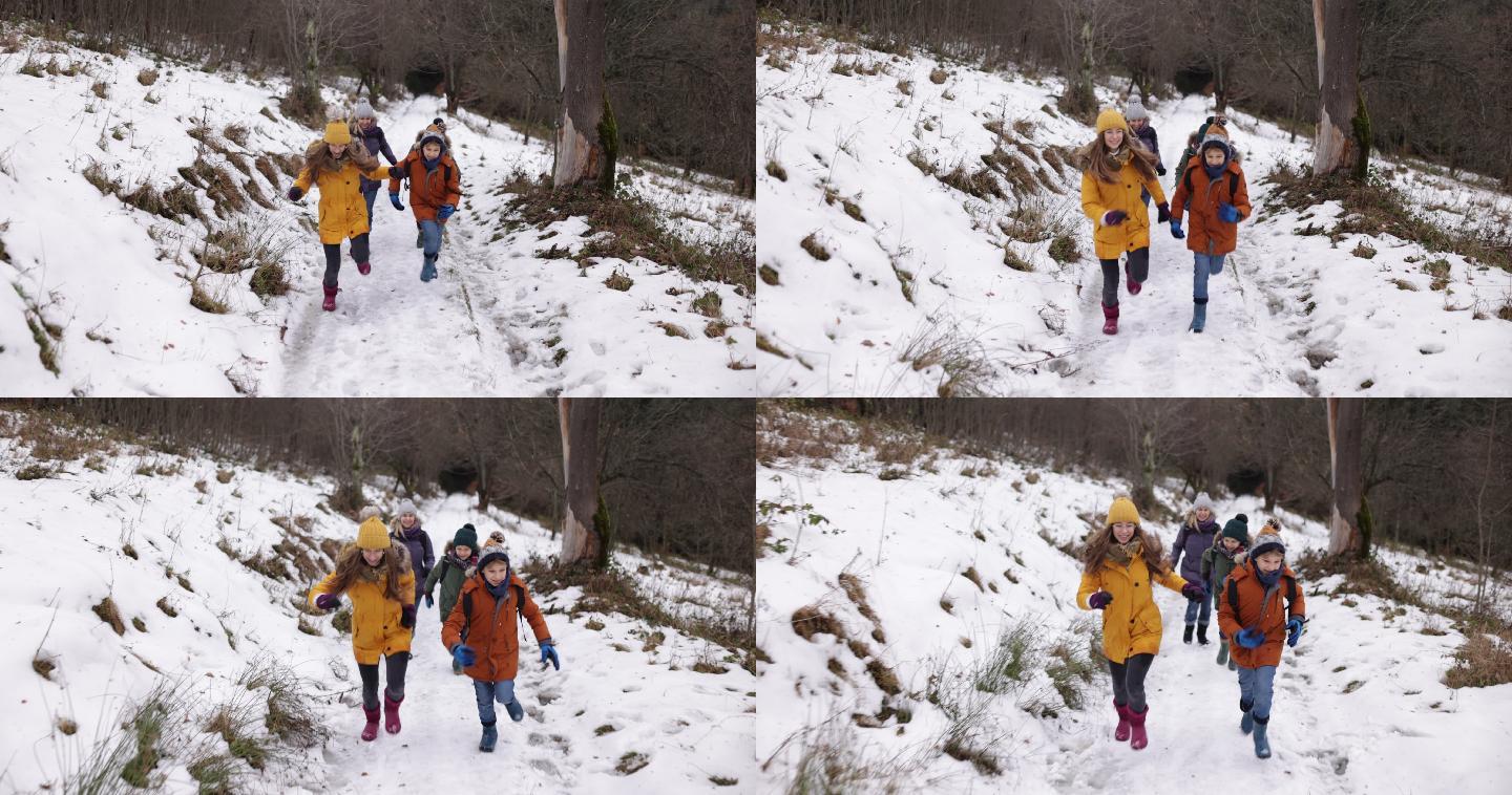 母亲和孩子们在冬季森林里徒步旅行。